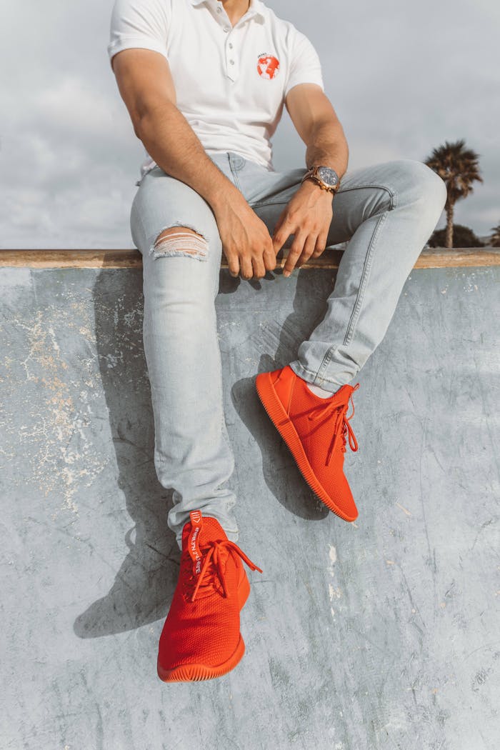 Man in vibrant red sneakers seated at a skate park in Rabat, Morocco.